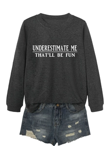 Detail of grey sweatshirt with UNDERESTIMATE ME print and frayed denim shorts
