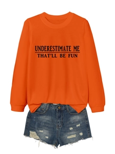 Macro detail of orange long sleeve sweatshirt with printed slogan and denim shorts