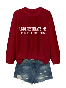 Close-up of burgundy long sleeve sweatshirt with white slogan print and denim shorts