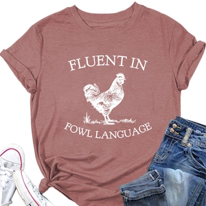 Flat lay of brick red T-shirt with rooster graphic and Fluent in Fowl Language slogan