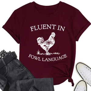 Close-up of burgundy t-shirt with rooster print and Fluent in Fowl Language text