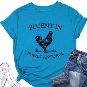 Flat lay of women's teal t-shirt with rooster print and denim shorts for causal outfit
