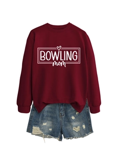Flat lay of maroon crew neck sweatshirt with white Bowling Mom print and denim shorts