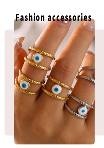 Macro shot of gold and silver evil eye rings with hammered metal texture and enamel inlay