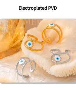 Detail of PVD electroplated gold and silver evil eye rings with hammered texture