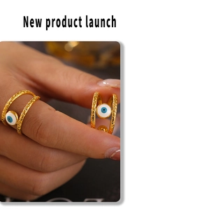 Detail of gold double-layer evil eye ring with hammered texture and blue enamel inlay