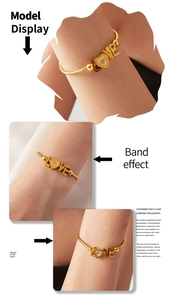 Detail view of gold LOVE bracelet with heart pendant and sparkling zircon on snake chain