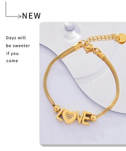 Detailed close-up of 18K gold-plated LOVE charm bracelet with heart-shaped zircon inlay