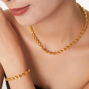 Ensemble collier et bracelet cœur tissé plaqué or 18k porté par un mannequin en gros plan
