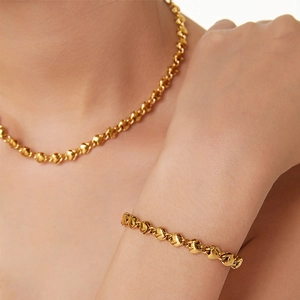 Ensemble collier et bracelet dorés 18 carats avec maillons en cœur portés par mannequin