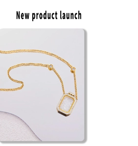 Close-up of gold stainless steel necklace featuring a crystal perfume bottle pendant
