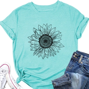 Gros plan du t-shirt bleu clair à motif tournesol assorti avec un jean et des baskets