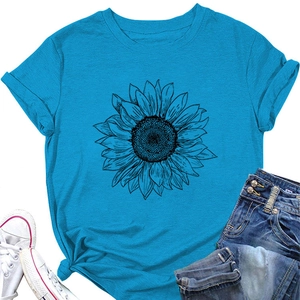 Détail du t-shirt turquoise à motif tournesol avec ourlet noué et manches retroussées