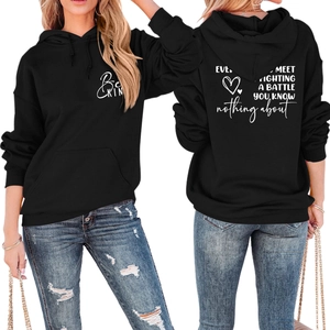 Front and back view of black hoodie showing Be Kind print and back slogan detail
