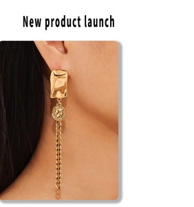 Detail of long gold tassel earring with geometric portrait coin on a female model