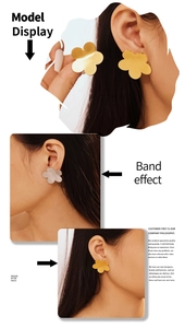 Close-up of elegant gold and silver five-petal flower stud earrings on female model