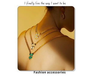Detail view of gold layered necklaces with clover pendants and matching hoop earring