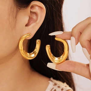 Chunky gold C-shaped hoop earrings with a polished mirror finish for a modern look