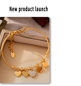 Detail of 18k gold plated stainless steel heart charm bracelet with sparkling zircons