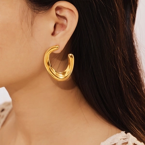 Polished 18k gold plated U-shaped titanium steel hoop earrings on female model