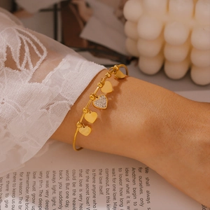Gold-plated stainless steel open bangle featuring five elegant dangling heart charms