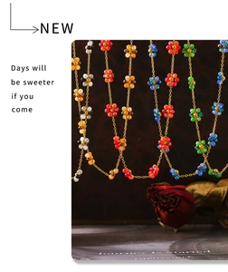 Macro detail of colorful beaded flower charms on elegant golden metallic chains