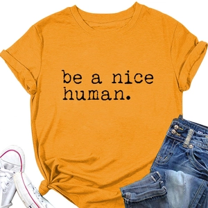 T-shirt jaune vif avec texte 'be a nice human' associé à un jean et des baskets