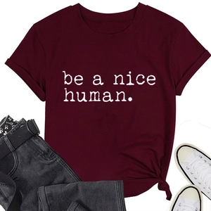 Détail du t-shirt bordeaux avec le slogan blanc 'be a nice human' en police dactylo