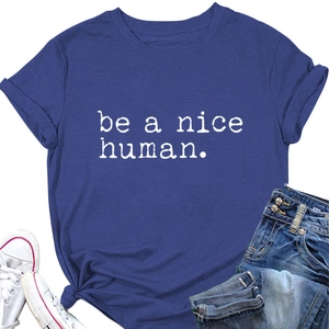 Détail du t-shirt bleu avec texte 'be a nice human', jeans et tennis blanches