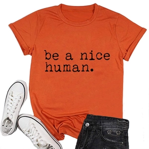 Mise à plat d'un T-shirt orange avec le slogan noir 'be a nice human' imprimé dessus