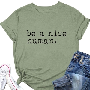 Gros plan du slogan 'be a nice human' sur un t-shirt en coton décontracté vert sauge