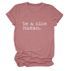 Détail du t-shirt rose poudré avec imprimé be a nice human et texture en coton