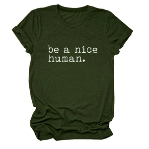 Détail des manches retroussées et du slogan 'be a nice human' sur t-shirt vert olive foncé