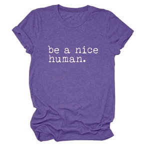 Détail du t-shirt violet avec texte 'be a nice human' blanc et manches retroussées