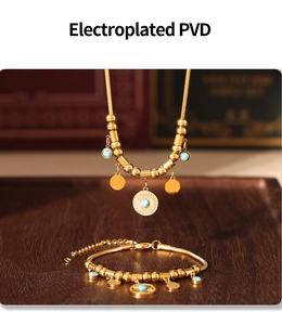 Détail d'un ensemble de bijoux dorés PVD avec perles de turquoise et pendentifs ronds