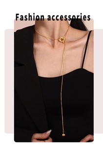 Détail d'un collier en Y en acier doré avec fermoir à bascule et pendentif perle
