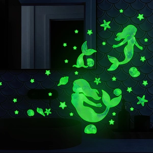 Luminous mermaid and stars wall stickers glowing green in a dark themed bathroom