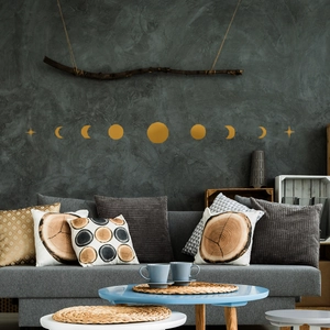 Modern gold moon phase wall decor set with stars hanging above a sofa in a living room