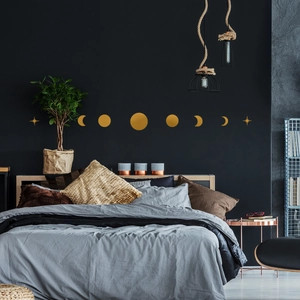 Detailed view of golden moon phase wall stickers with stars on a dark bedroom wall