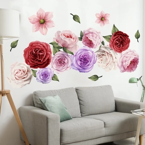 Vista detallada de adhesivos de pared florales grandes sobre un sofá gris en un salón