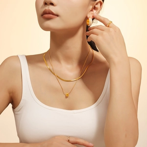 Collar de doble capa dorado con cuentas minimalista y pendientes de aro a juego