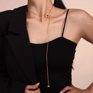 Collier lariat en acier inoxydable doré avec fermoir OT et perle sur un mannequin