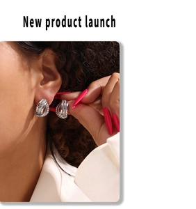 Close-up of twisted knot silver earrings with pave-set zircon stones on a model ear