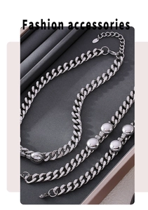 Close-up of silver Cuban link necklace and bracelet set with smooth ball accents