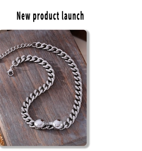 Detailed view of silver cuban chain necklace with spherical pendants on wooden background