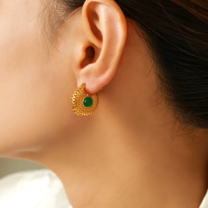 Boucles d'oreilles vintage françaises en verre vert et or portées par un mannequin