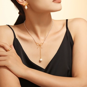 Collier ras du cou en perles avec pendentif nœud doré et boucles d'oreilles assorties