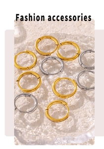 Close-up of gold and silver hoop earrings with cubic zirconia on textured glass