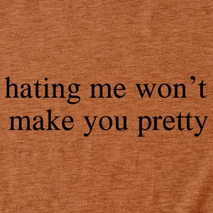 Close-up of terracotta cotton T-shirt with 'hating me won't make you pretty' print