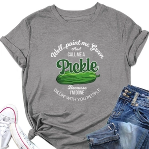 Flat lay of a grey slogan t-shirt with green pickle graphic, denim jeans and white sneakers